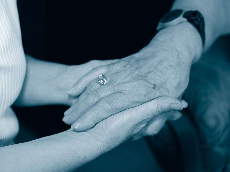 Zwei Jüngere Hände halten eine ältere Hand
